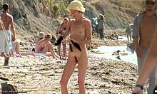 苗条的年轻女子在裸体海滩上展示她惊人的身体